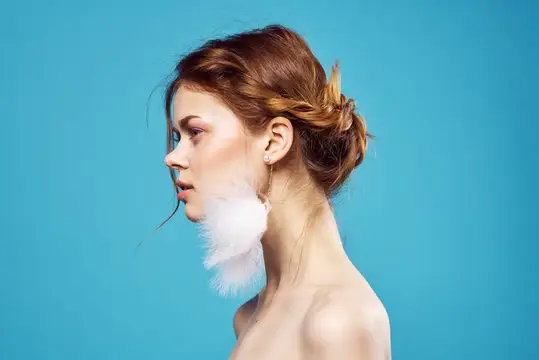 Красивая женщина с обнаженными плечами, серьги, украшения, мода, синий фон