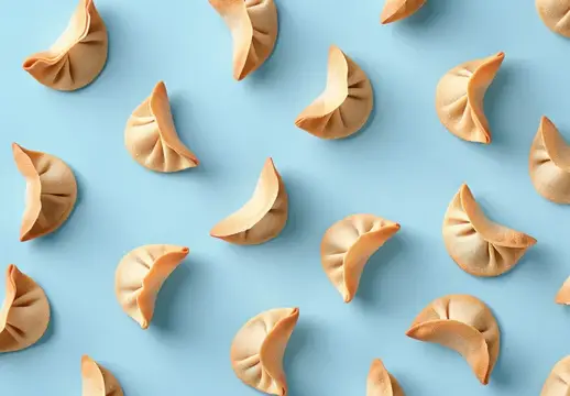 Вареники и пельмени разложены узором на голубом фоне