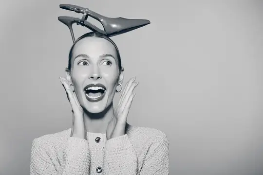 Удивлённая женщина с туфлей на голове