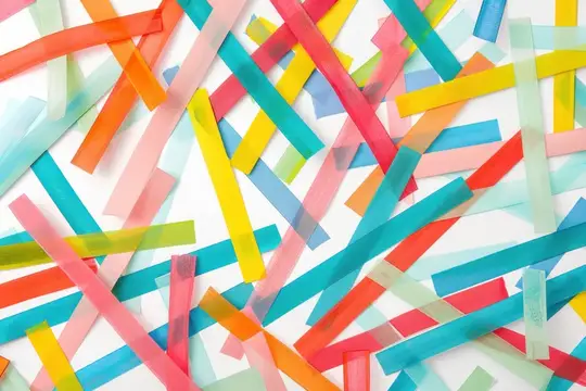 Разноцветные полупрозрачные полоски бумаги хаотично разбросаны по белому фону