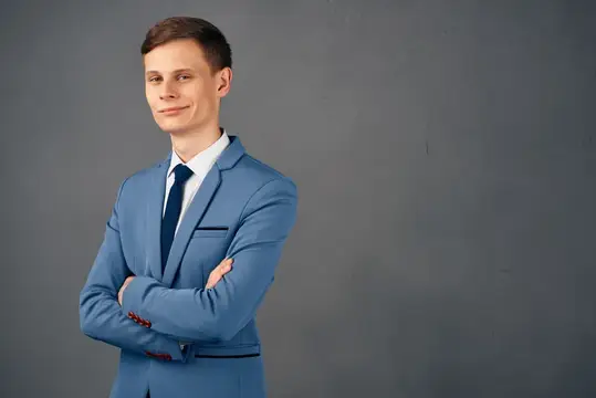 Улыбающийся бизнесмен в костюме с документами на изолированном фоне выглядит профессионально