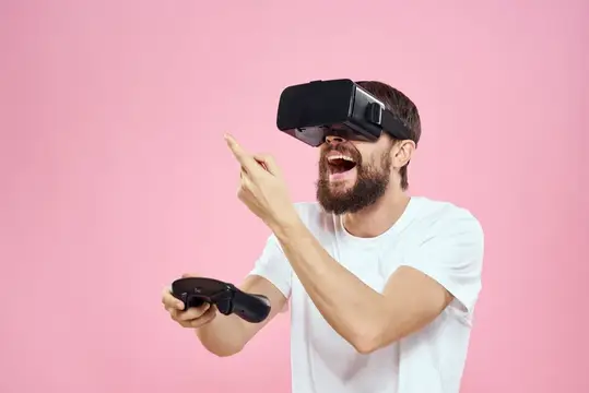 Бородатый мужчина в VR-очках смеётся и указывает пальцем вверх