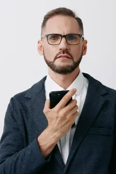 Мужчина в очках и деловом костюме держит смартфон