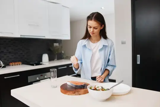 Молодая женщина готовит ужин на светлой кухне