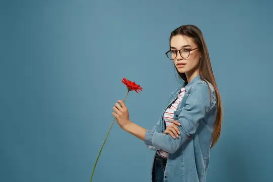 Девушка в очках с красным цветком на синем фоне