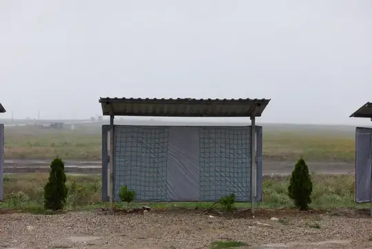Остановка с пластиковыми стенами в пустом поле в тумане