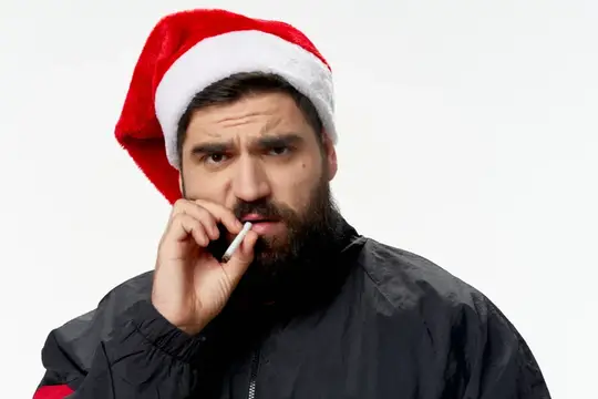 Плохой Санта с бородой в шапке с сигаретой во рту
