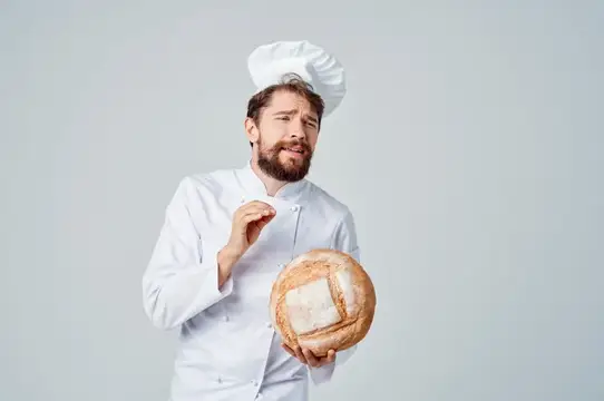 Профессиональные эмоции шеф-повара на кухне, работающего с хлебобулочными изделиями