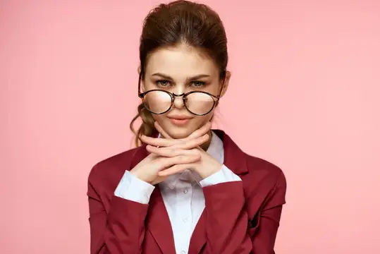Деловая женщина в костюме и очках на розовом фоне