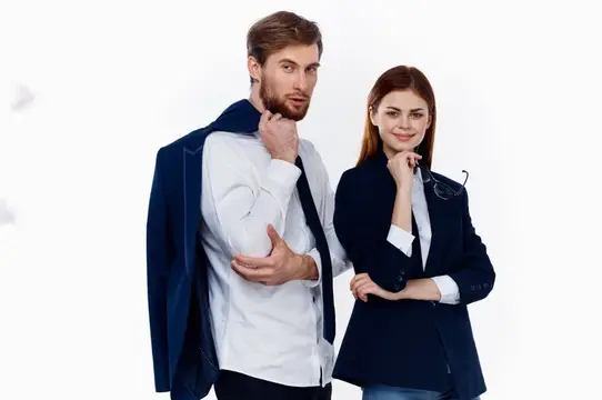 Уверенные мужчина и женщина в деловых костюмах на белом фоне
