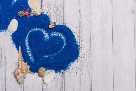 Сердечко из синего песка и ракушек на белых досках