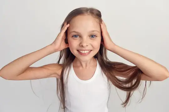 Веселая девушка в белой футболке улыбается