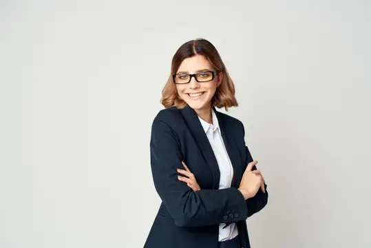 Улыбающаяся женщина в очках и деловом костюме на светлом фоне