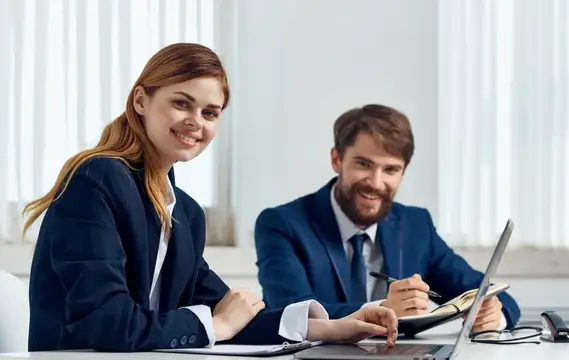 Улыбающиеся мужчина и женщина в офиса за работой