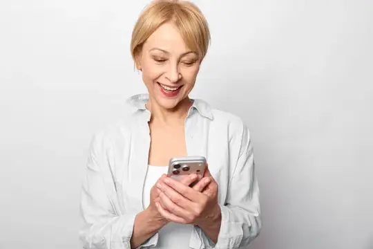 Пожилая улыбающаяся женщина со смартфоном