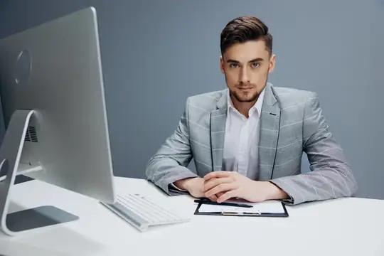 Красивый мужчина работает за компьютером в офисе на изолированном фоне