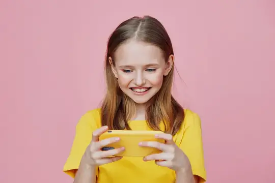Улыбающаяся девочка с телефоном на розовом фоне