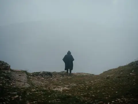 Одинокий путник в тумане на вершине горы