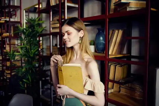 Красивая женщина с книгой в руках отдыхает в кафе
