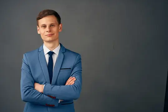 Деловой мужчина в костюме, излучающий уверенность в себе, позирует на изолированном фоне