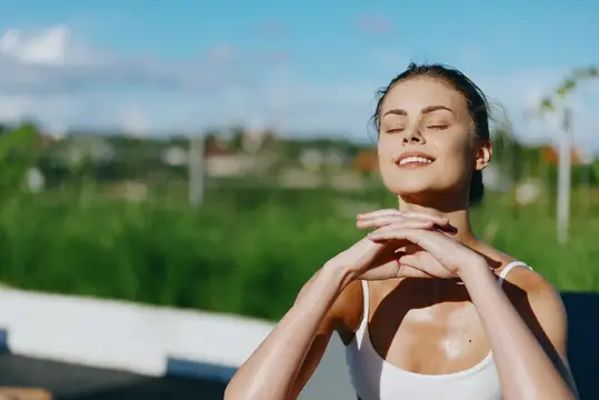 Солнечная сцена на открытом воздухе: улыбающаяся женщина с закрытыми глазами, грациозная поза, яркий свет, свежий воздух, повседневная одежда, расслабленное настроение, естественные текстуры…