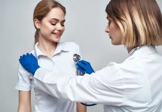 Женщина-врач в синих перчатках делает инъекцию шприцем, общаясь с пациентом