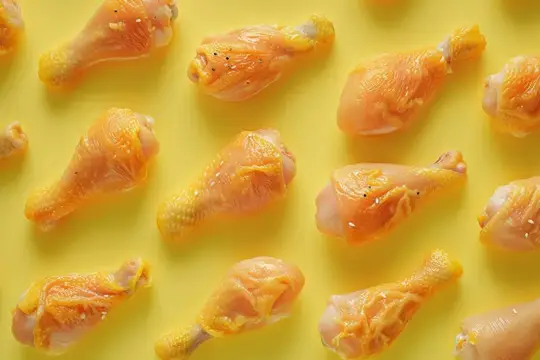 Ассорти из кусочков курицы, разложенных на желтом фоне