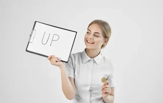 Улыбающаяся девушка в белой рубашке держит планшет с надписью UP