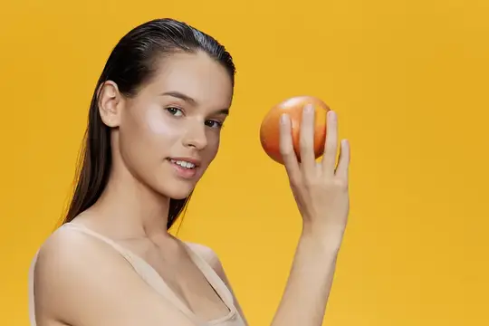 Молодая женщина с яблоком на желтом фоне