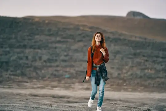 Женщина-туристка идет по природе в горах, наслаждаясь свежим воздухом