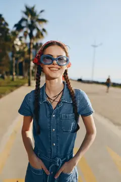 Улыбчивая девушка с двумя косами и в солнечных очках на набережной
