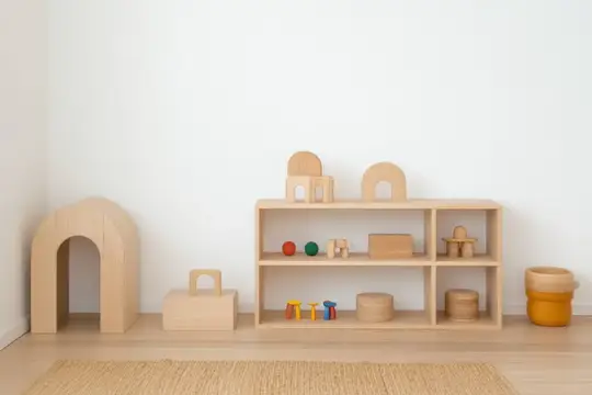 Светлая и просторная игровая комната с минималистичными деревянными игрушками и игровыми конструкциями для детей, подчеркивающая успокаивающую и естественную эстетику для творческой игры