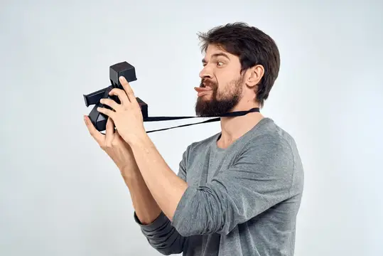 Бородатый мужчина с VR-очками на шее показывает язык