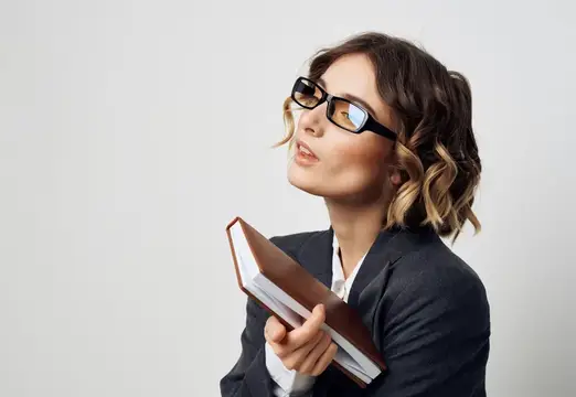 Деловая женщина держит в руках книгу на светлом фоне