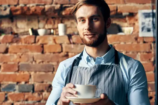Бариста в кофейне работает с чашкой кофе