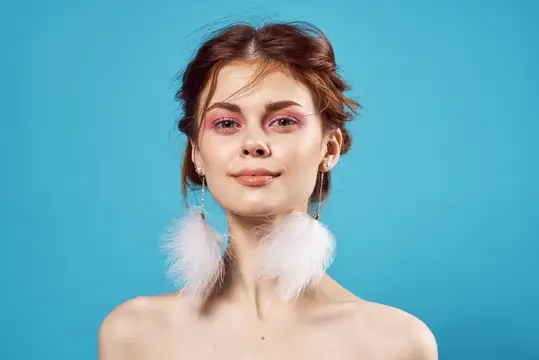 Привлекательная женщина с обнажёнными плечами, косметика, позирование, мода, синий фон