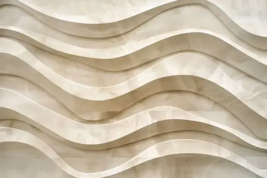 Волнистый рельеф из светлого камня на стене