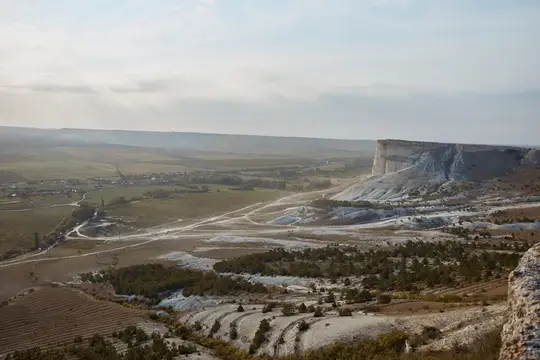 Панорама долины с белой скалой и полями в утренней дымке