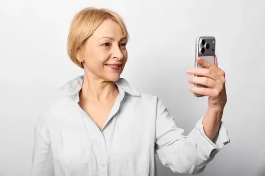 Пожилая женщина делает селфи на смартфон