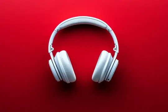 Белые наушники на красном фоне с местом для текста