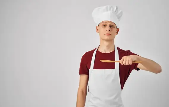 Повар-мужчина на кухне самолёта с кухонной утварью выполняет свою работу