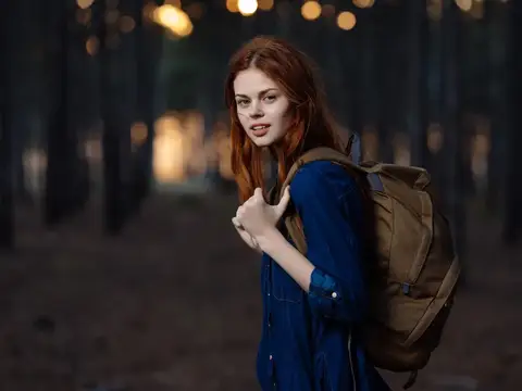 Женщина-туристка с рюкзаком путешествует по лесу, ощущая свободу