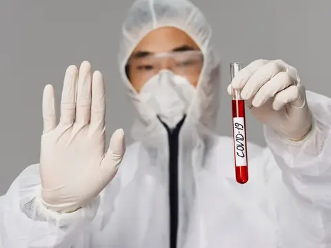 Мужчина держит в руках вакцину от COVID-19, что символизирует лечение, здоровье, лабораторию и науку