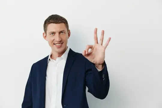 Улыбающийся мужчина в пиджаке показывает жест о'кей