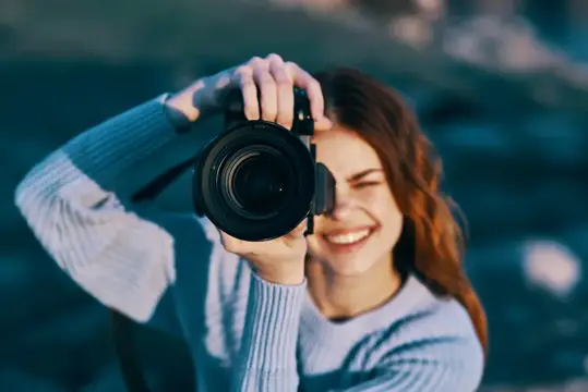 Симпатичная женщина-фотограф на фоне скалистых гор, крупный план, профессиональный снимок