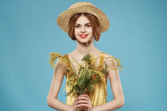 Улыбчивая девушка в соломенной шляпе с букетом жёлтых цветов