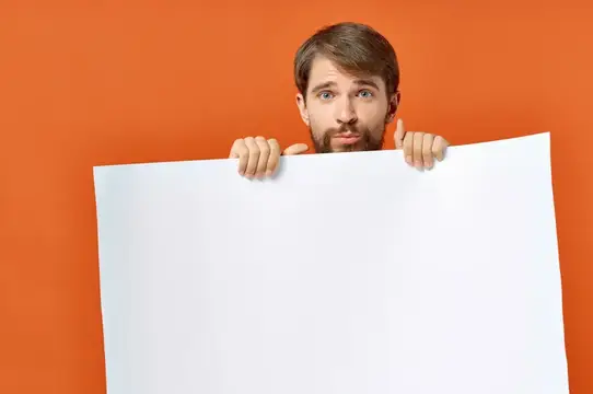 Бородатый мужчина с плакатом в руке на оранжевом фоне