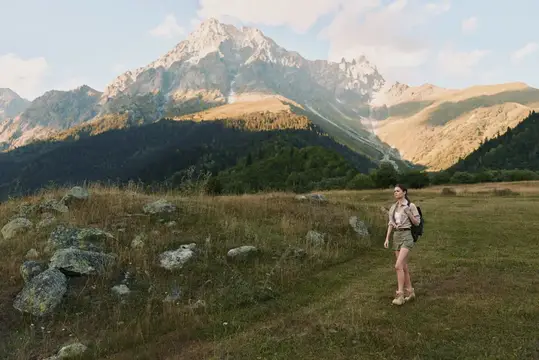 Непринужденный вид женщины на тропе в альпийской местности, наслаждающейся природой, свежим воздухом и открытым пространством, подчеркивающий фитнес, путешествия и осознанную жизнь на природе