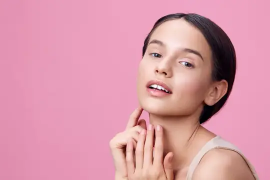 Молодая женщина с естественным макияжем на розовом фоне