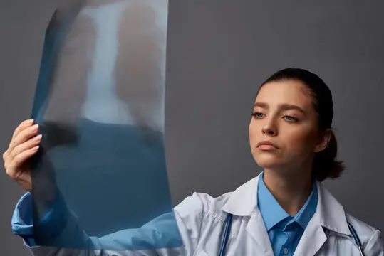 Молодая женщина-врач рассматривает рентгеновский снимок